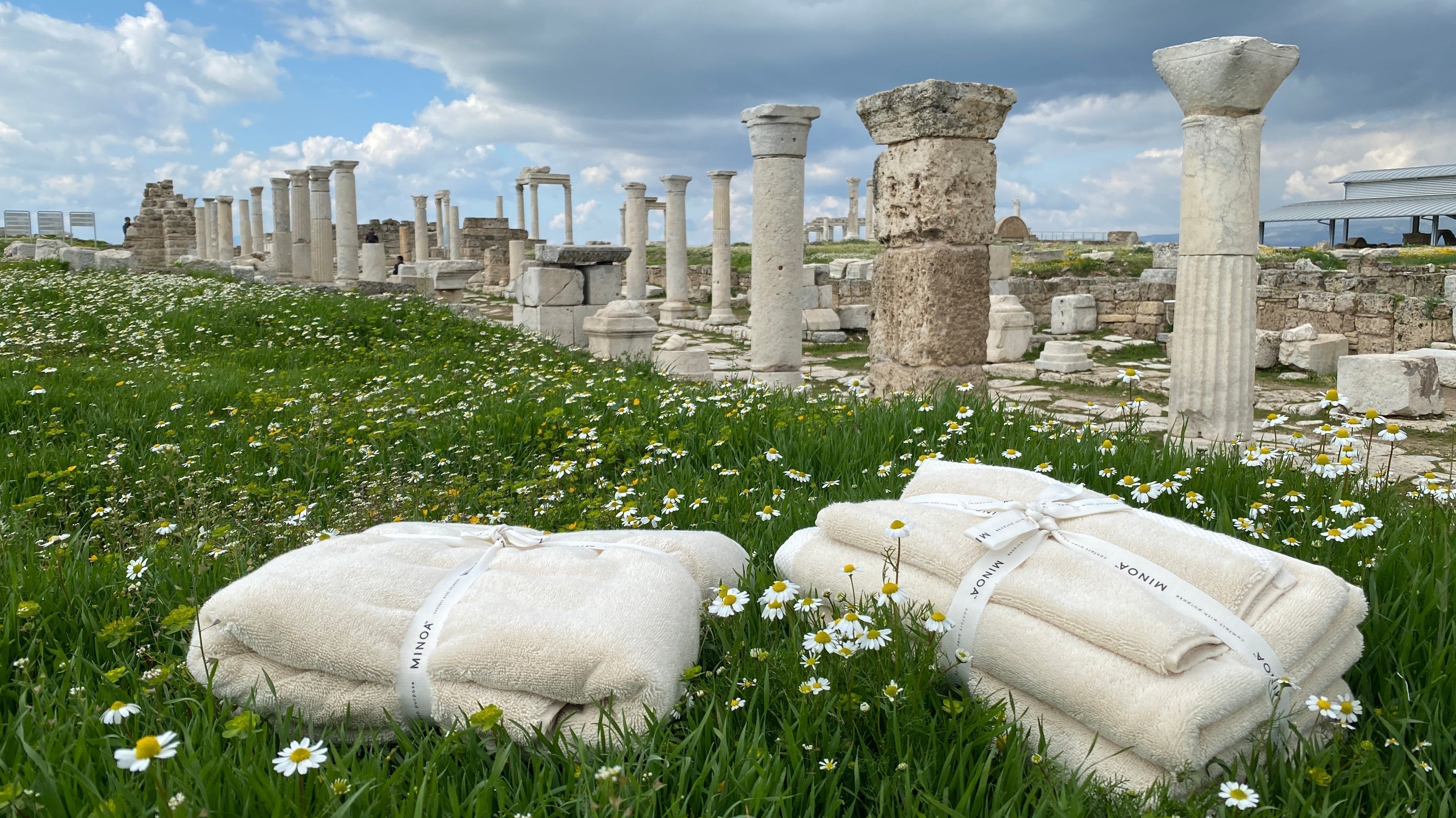 Two Minoa aegean cotton towels laying on the grass