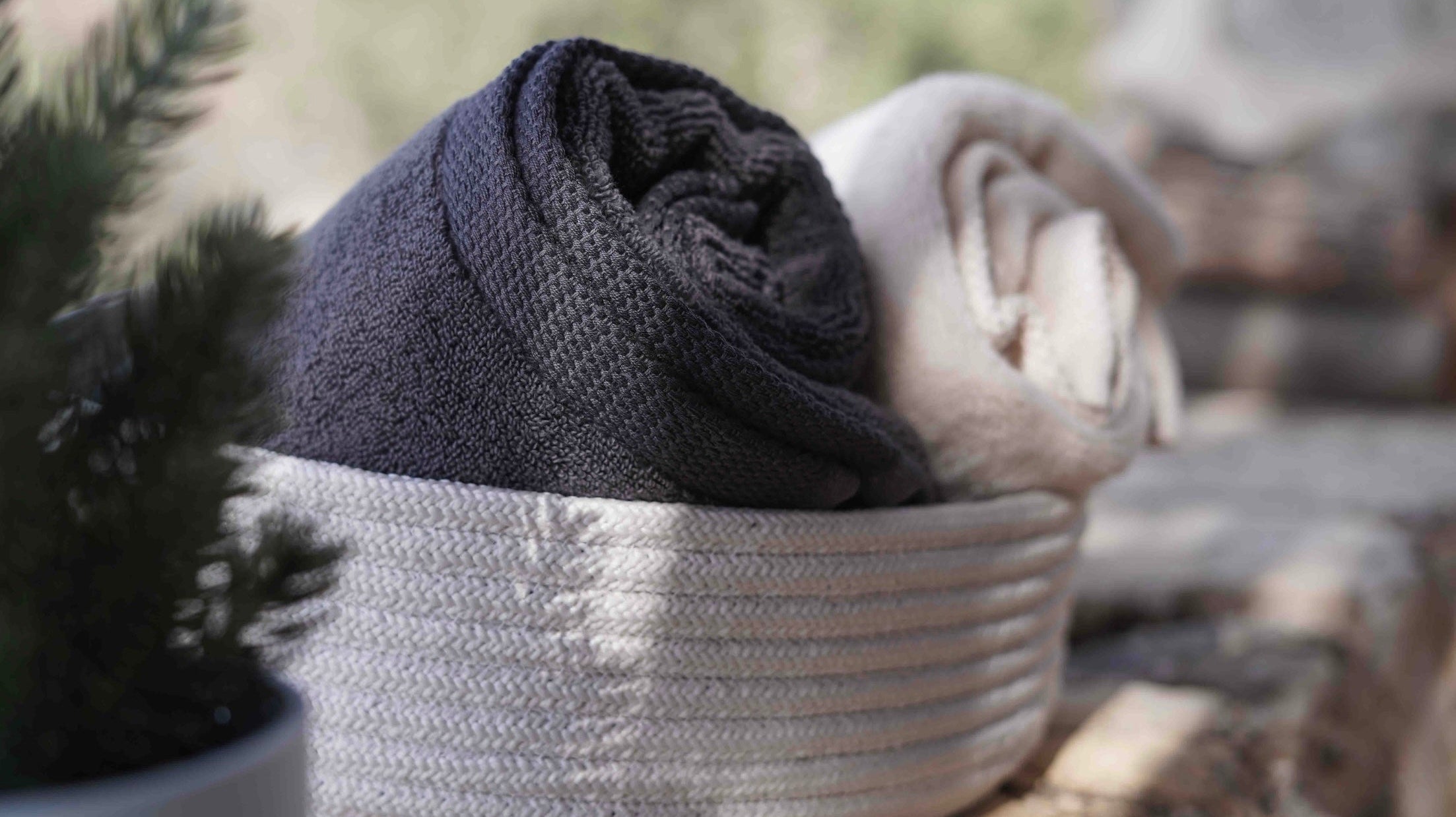 Two minoa towels in a basket (left black, right white)