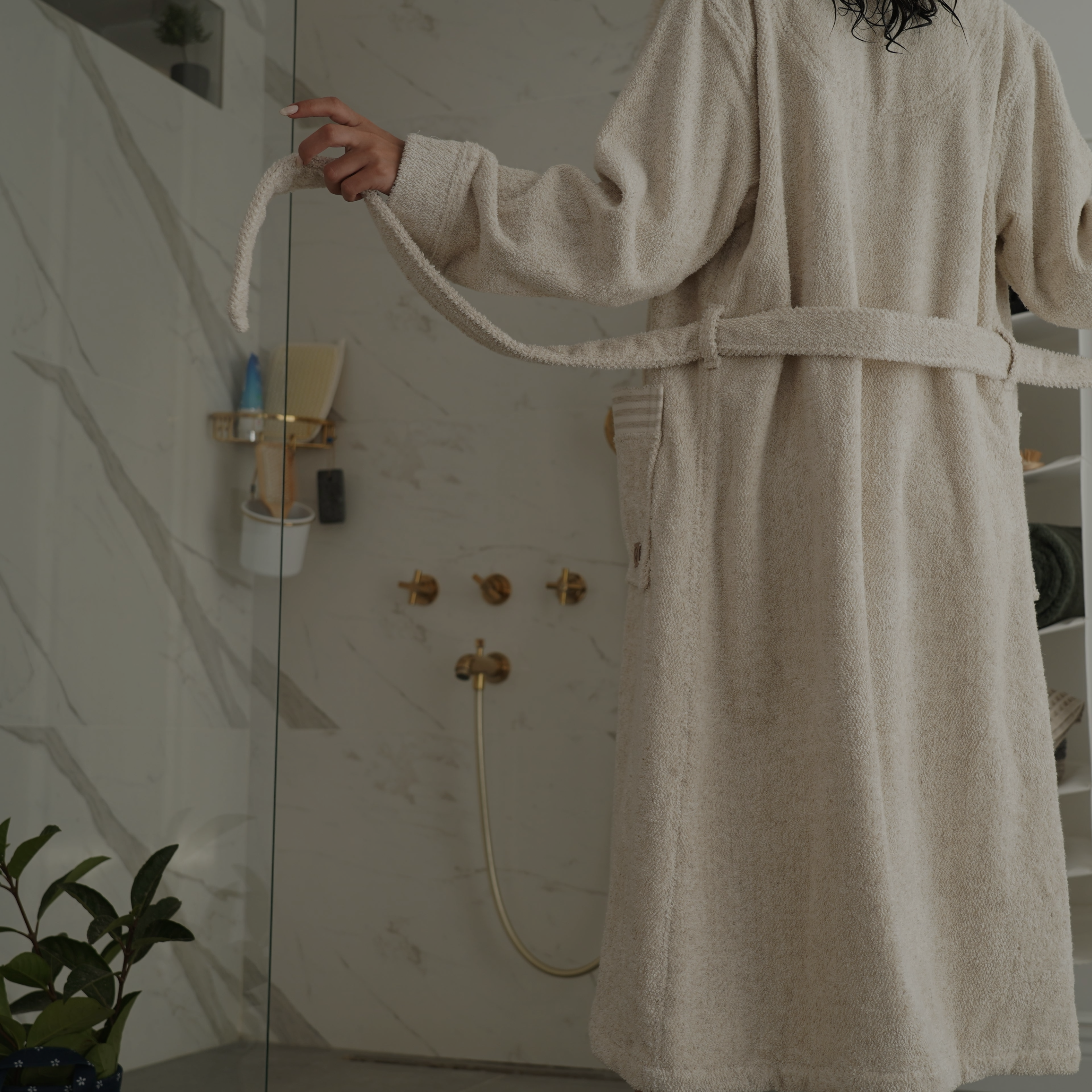 this is a lady untying her bath robes and prepared to get showered