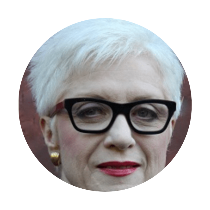 Woman wearing black glasses with gold earrings