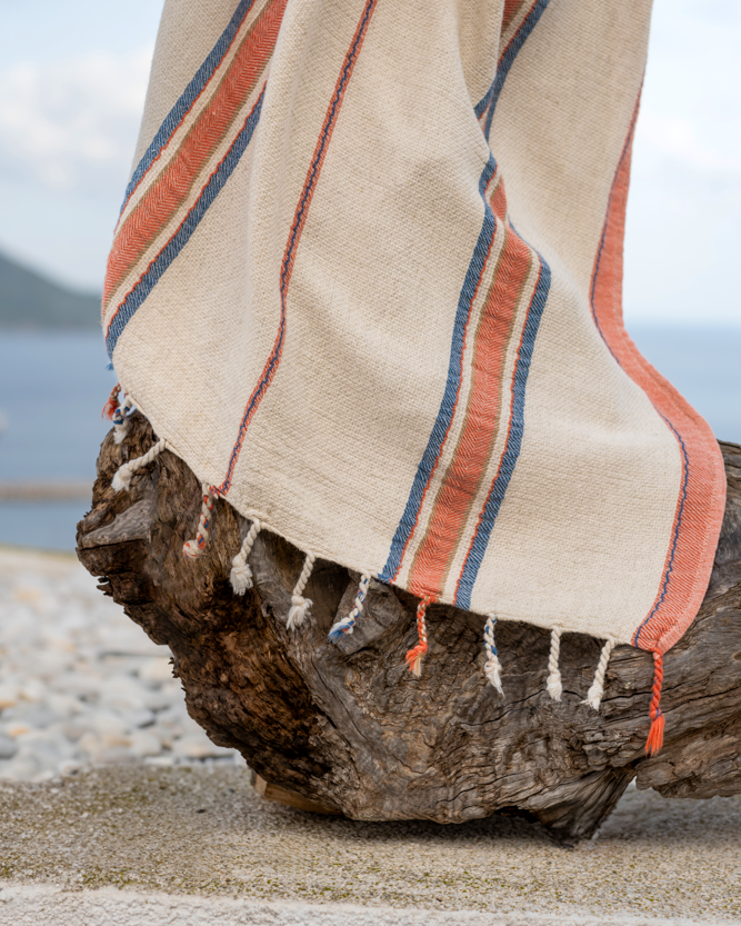 Luxury, sustainable Elba Turkish Towel beside the beach along with a rock