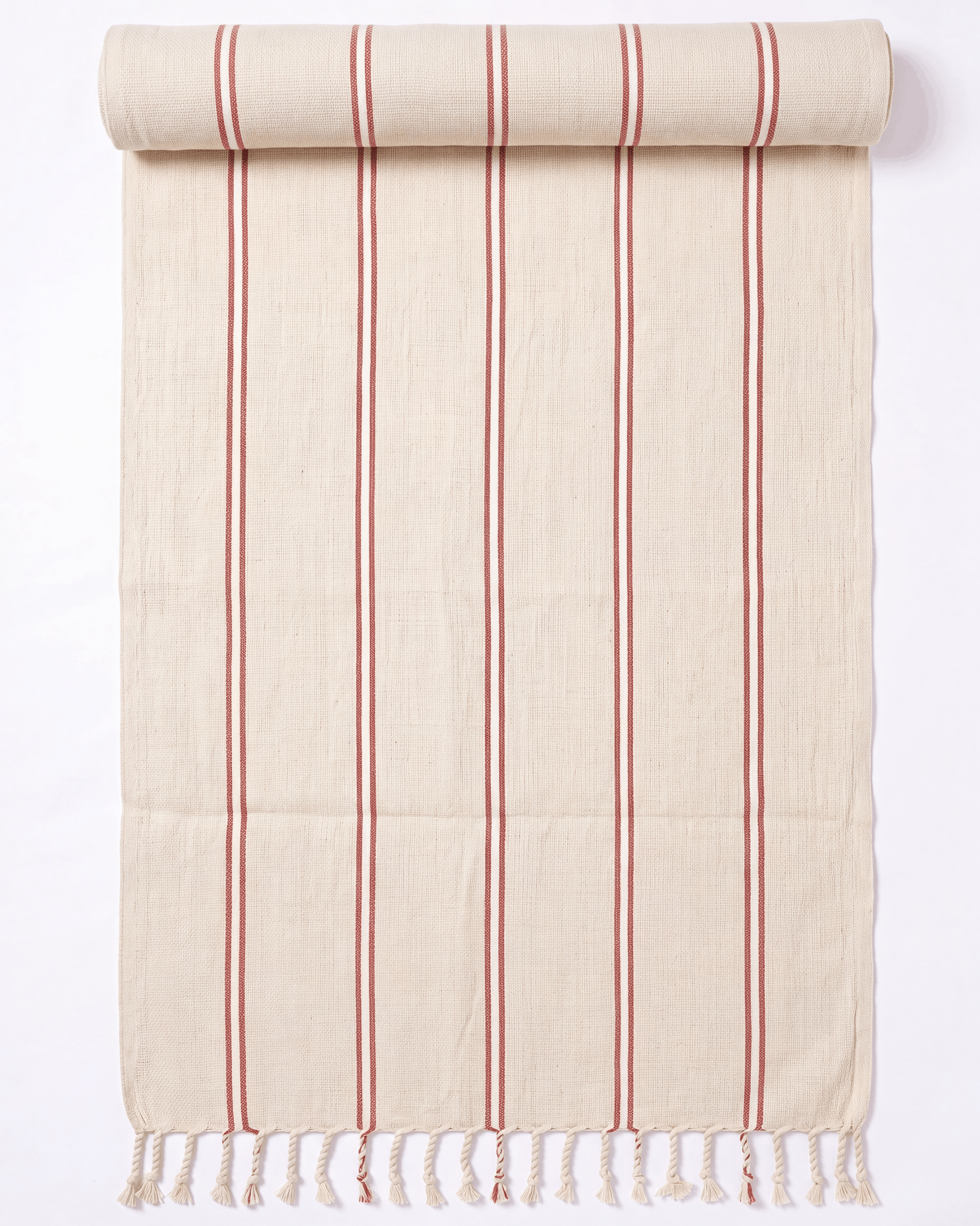 A cream-colored cotton towel with vertical red stripes and fringed tassels on one end, shown partially rolled at the top against a white background.