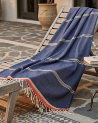 Blue towel draped over a lounge chair on a patterned patio