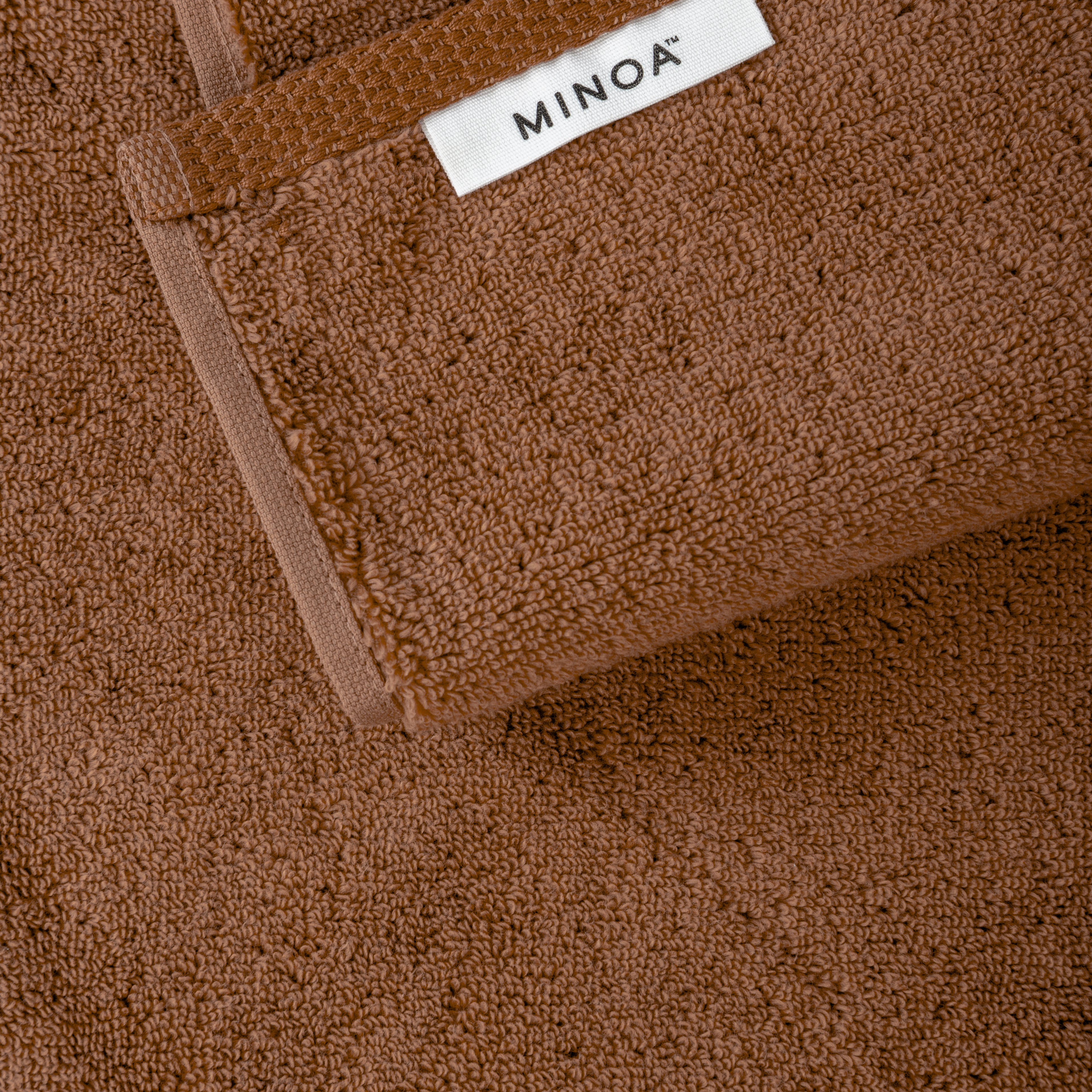 Brown towel with a visible 'MINOA' label