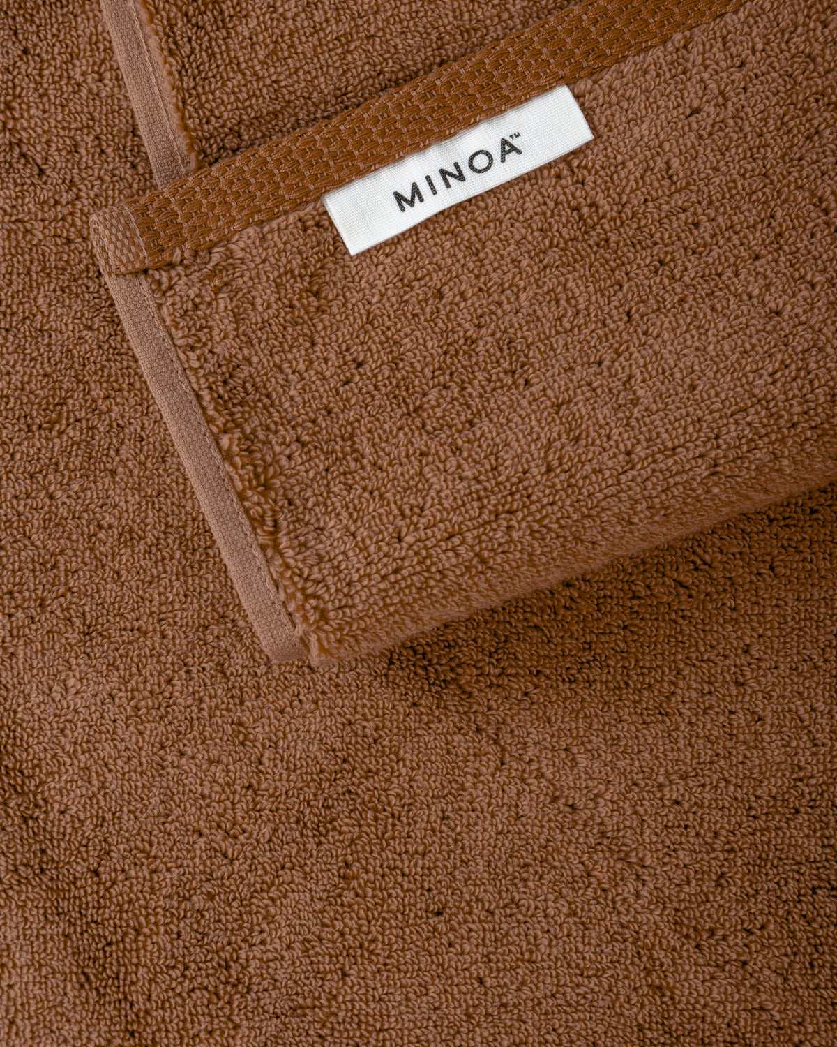 Brown towel with a visible 'MINOA' label