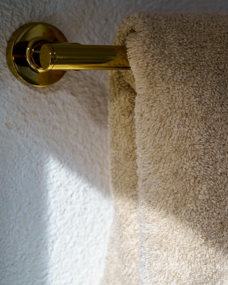 Raisa Hemp & Organic Cotton Hand Towel in Vanilla Embrace, hung neatly on a bathroom hanger, showcasing its soft texture and natural colour in a relaxed, stylish setting