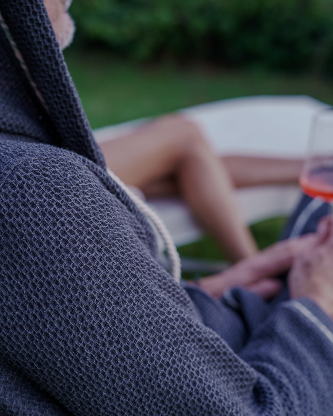 A male wearing Minoa's Naia Panama Weave Mens Robe showcasing its luxuriously soft texture