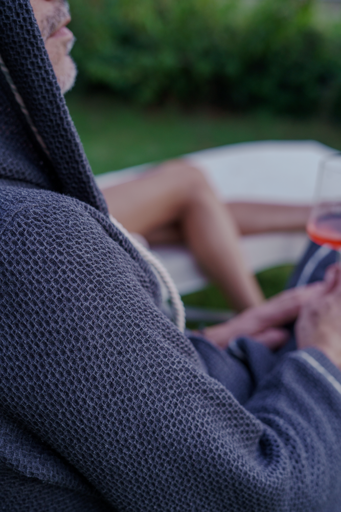 A male wearing Minoa's Naia Panama Weave Mens Robe showcasing its luxuriously soft texture