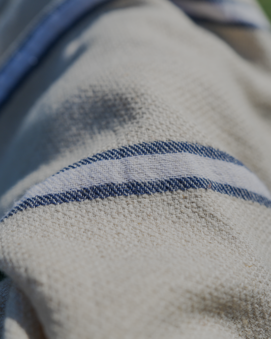 Blue and white Anakao 215 gram Aegean Cotton and Linen Turkish towel under the sunshine highlighting the soft texture and organic bath towel quality