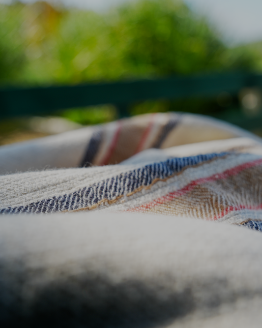 Close-up of Sand & Navy luxury organic Elba Turkish towel neatly placed on a bench table, highlighting its soft texture and elegant design