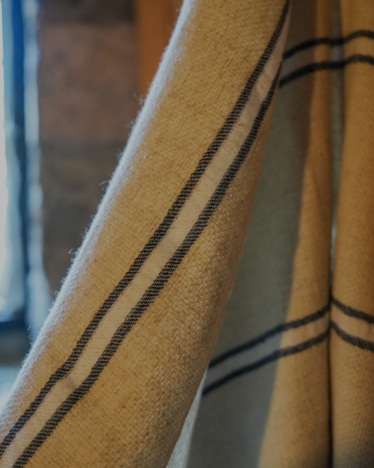 Blue and white Anakao 215 gram Aegean Cotton and Linen Turkish towel hanging on the wall showcasing the soft texture of an organic bath towel