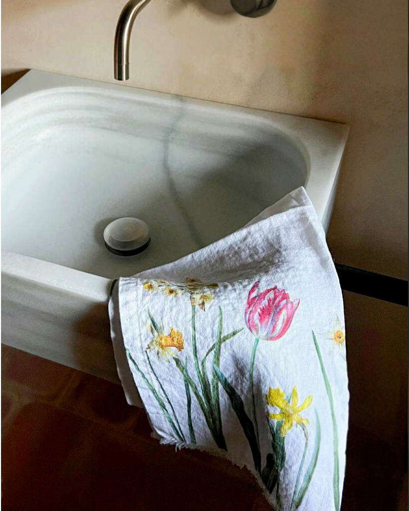 Towel with floral design hanging over a sink