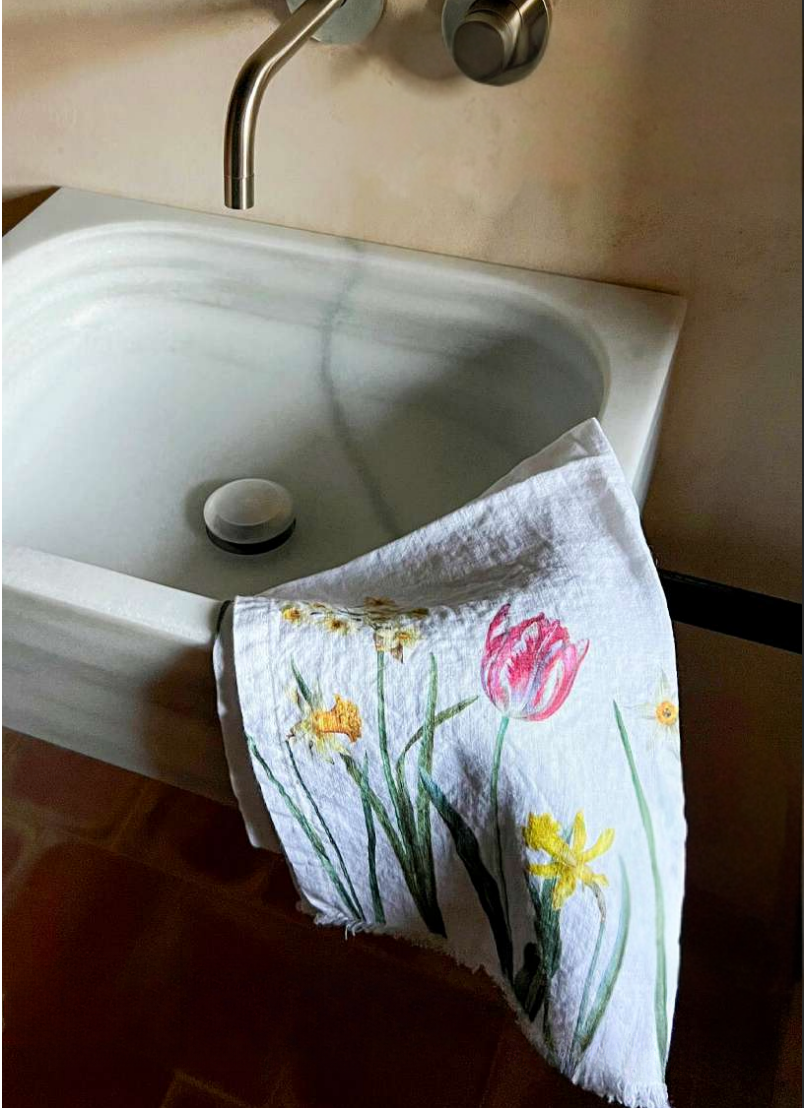 Towel with floral design hanging over a sink