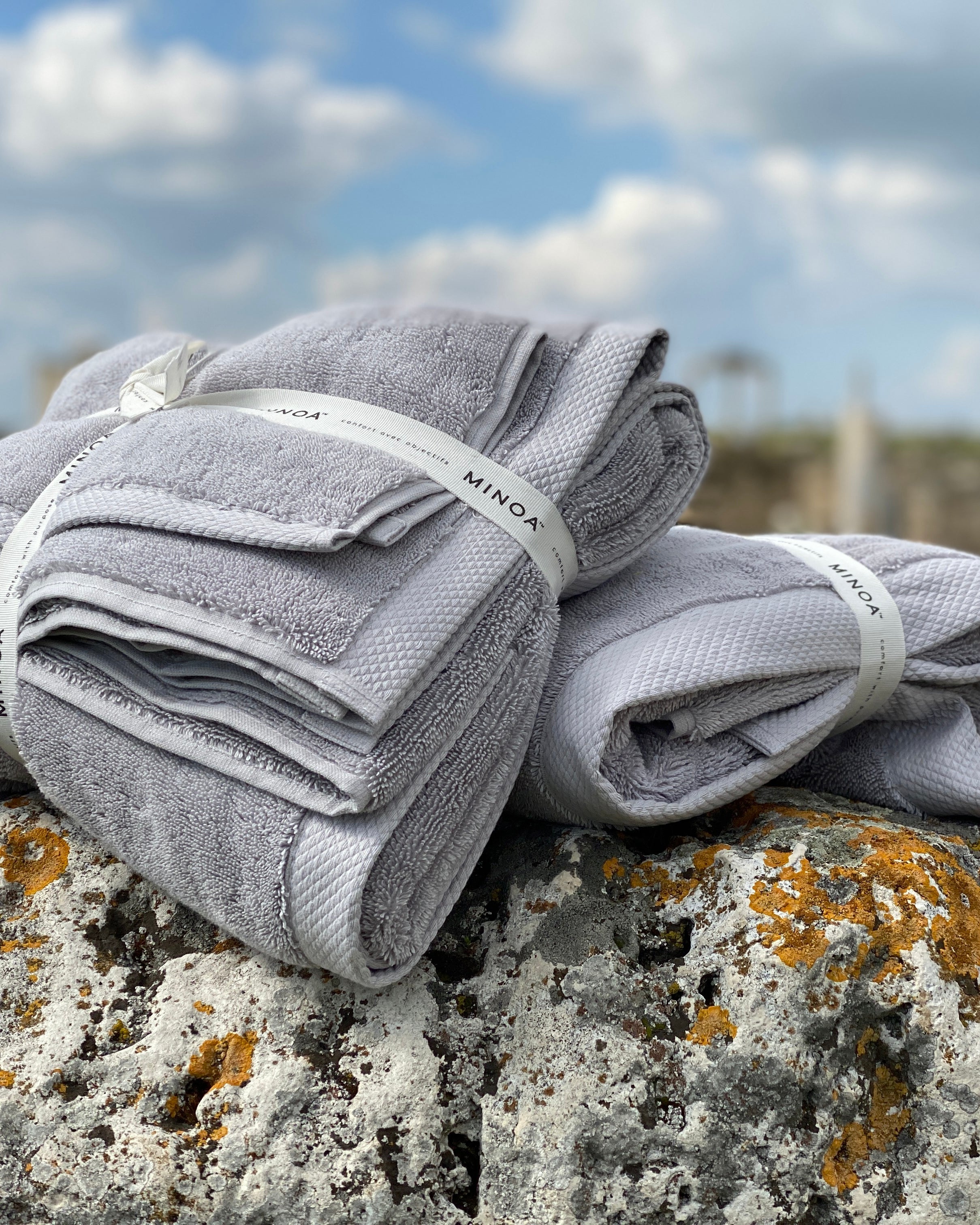 Two Silver Suede Monte Rosa 820-gram organic Aegean cotton luxury bath towel sets on a natural background, highlighting plush texture, luxurious feel, and eco-friendly design