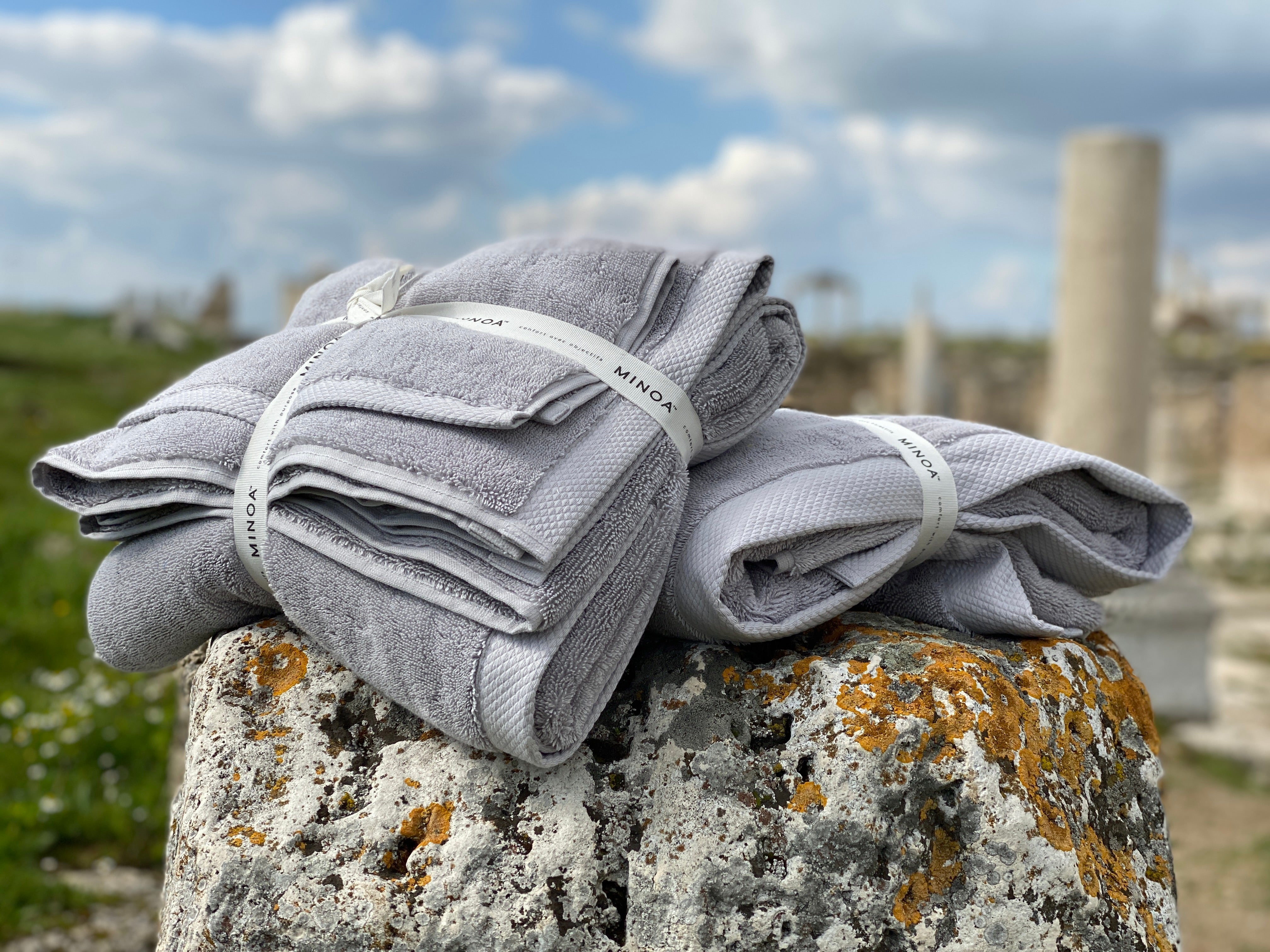 Two Silver Suede Monte Rosa 820-gram organic Aegean cotton luxury bath towel sets on a natural background, highlighting plush texture, luxurious feel, and eco-friendly design