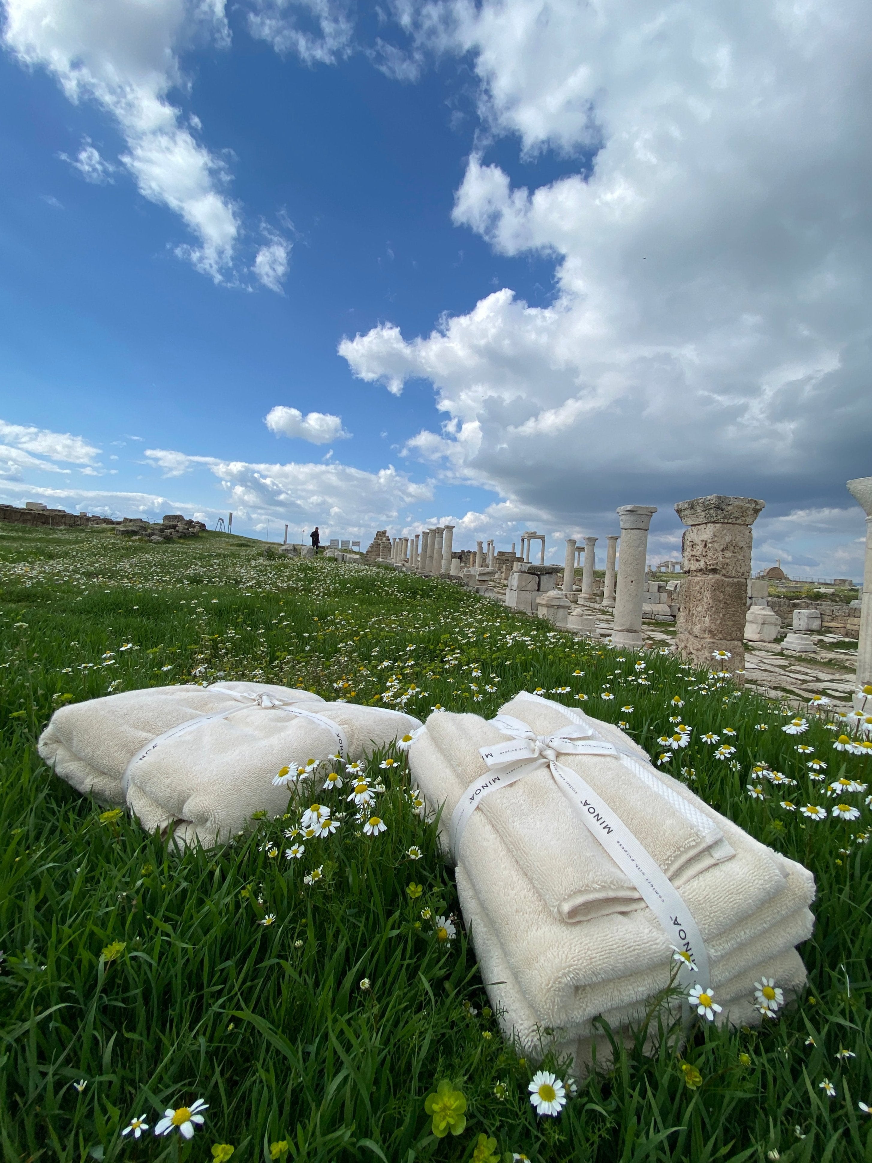 Two Moonlight Pearl Monte Rosa 820-gram organic Aegean cotton luxury bath towel sets gently placed on a natural background, highlighting soft plush texture and eco-friendly design
