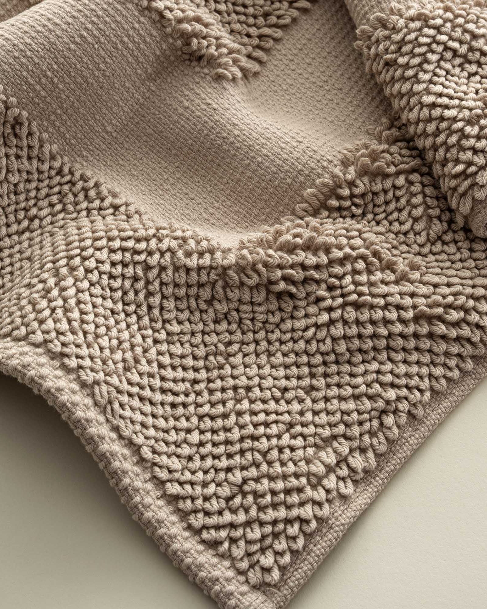 Close-up of the Kaia Aegean Cotton Bath Mat in Whispering Sands, highlighting its plush texture, subtle warmth, and high-quality craftsmanship