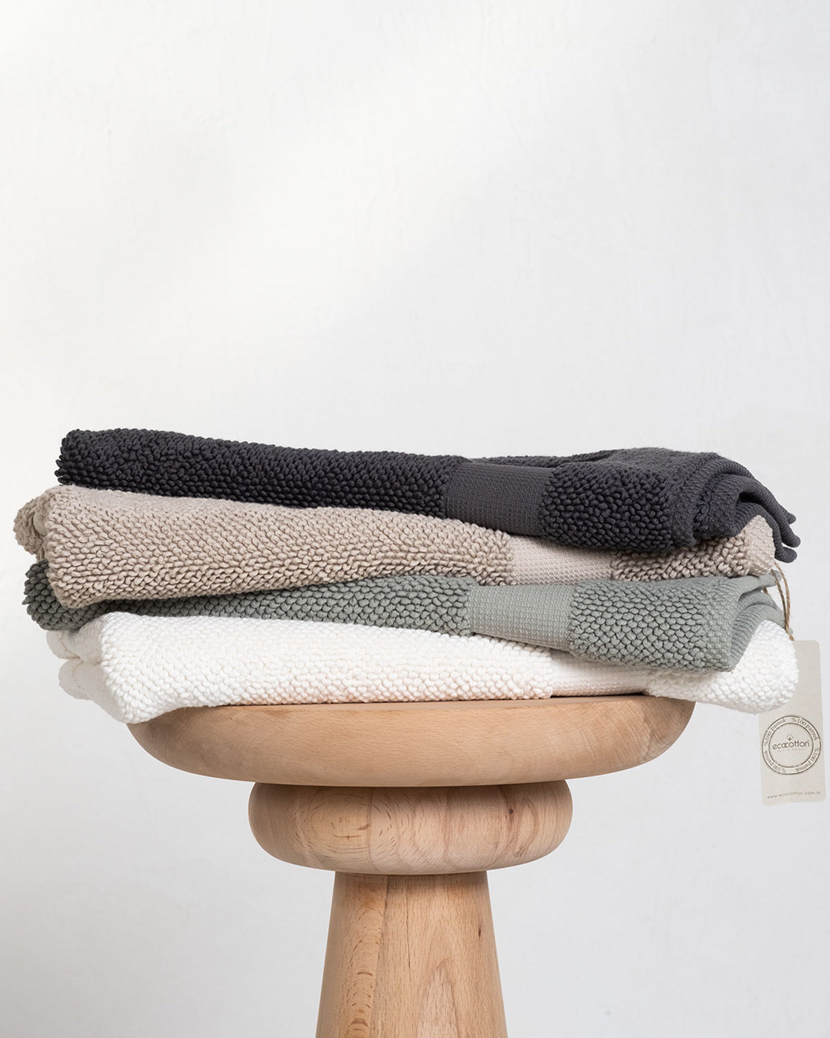 Kaia Aegean Cotton Bath Mats displayed in four colours—Charcoal Charm, Whispering Sands, Meadow Sage, and Pearl Petal—showcasing their soft texture, elegant tones, and premium quality