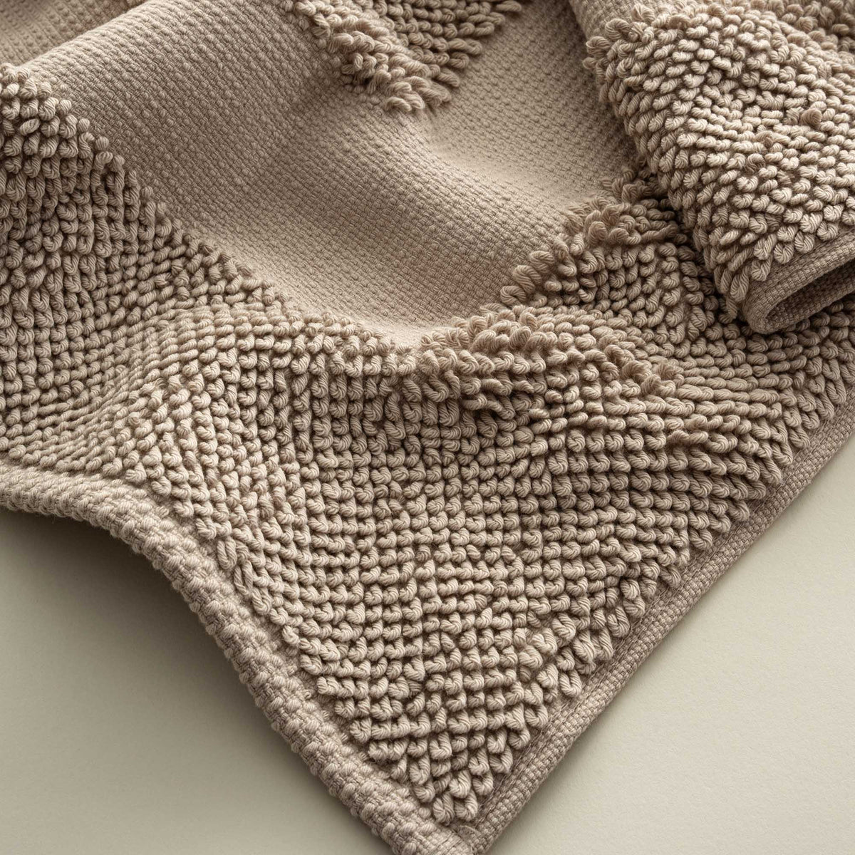 Close-up of the Kaia Aegean Cotton Bath Mat in Whispering Sands, highlighting its plush texture, subtle warmth, and high-quality craftsmanship