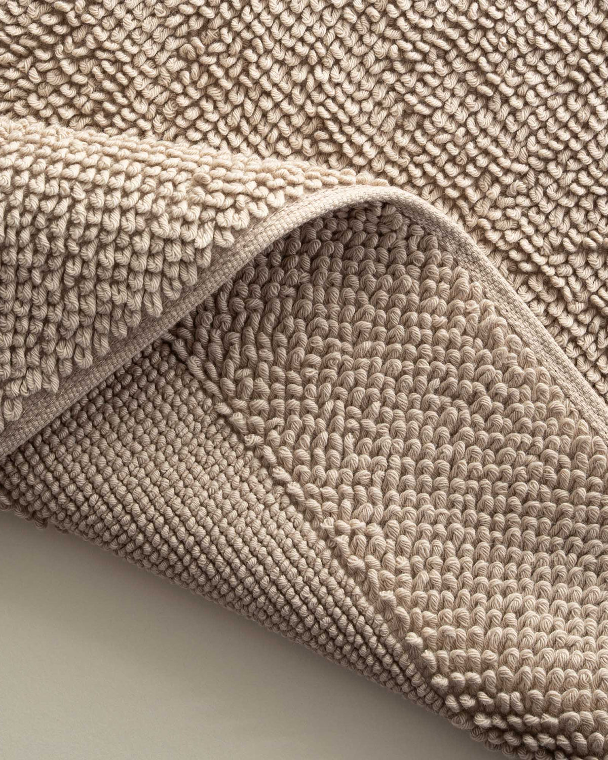 Close-up of the Kaia Aegean Cotton Bath Mat in Whispering Sands, highlighting its plush texture, subtle warmth, and high-quality craftsmanship