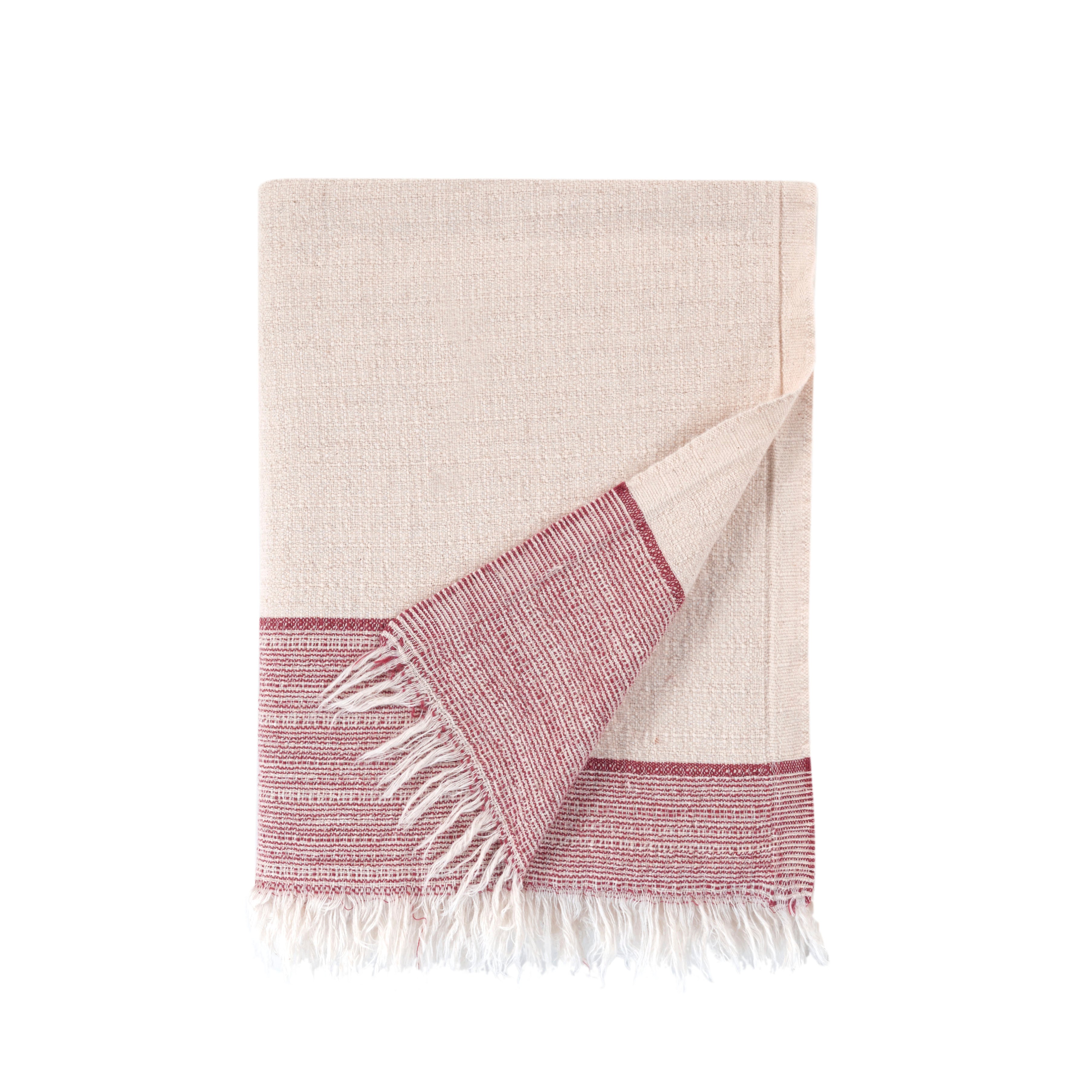 Beige and pink woven towel with fringes on a white background