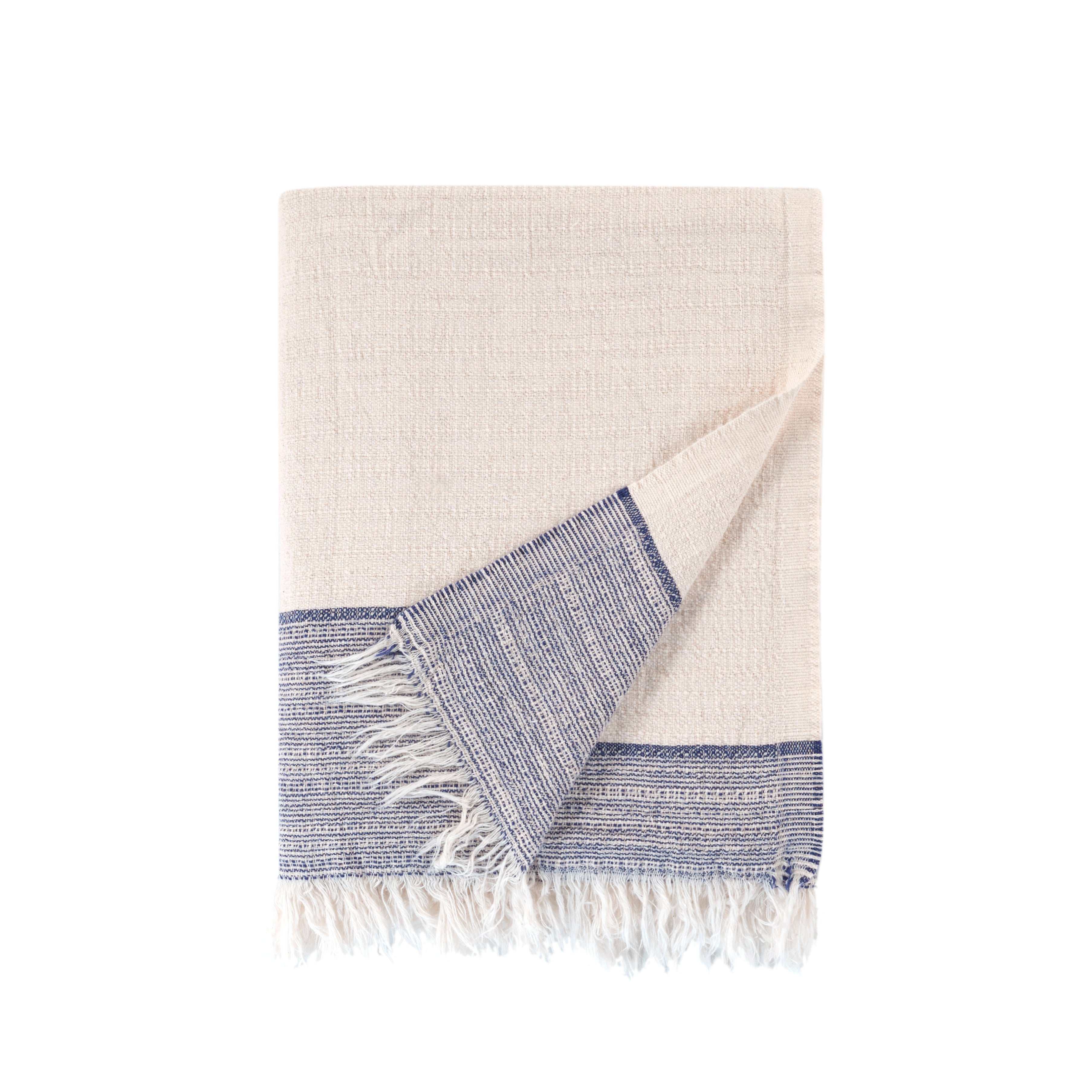 Beige towel with blue border and white fringe on a white background