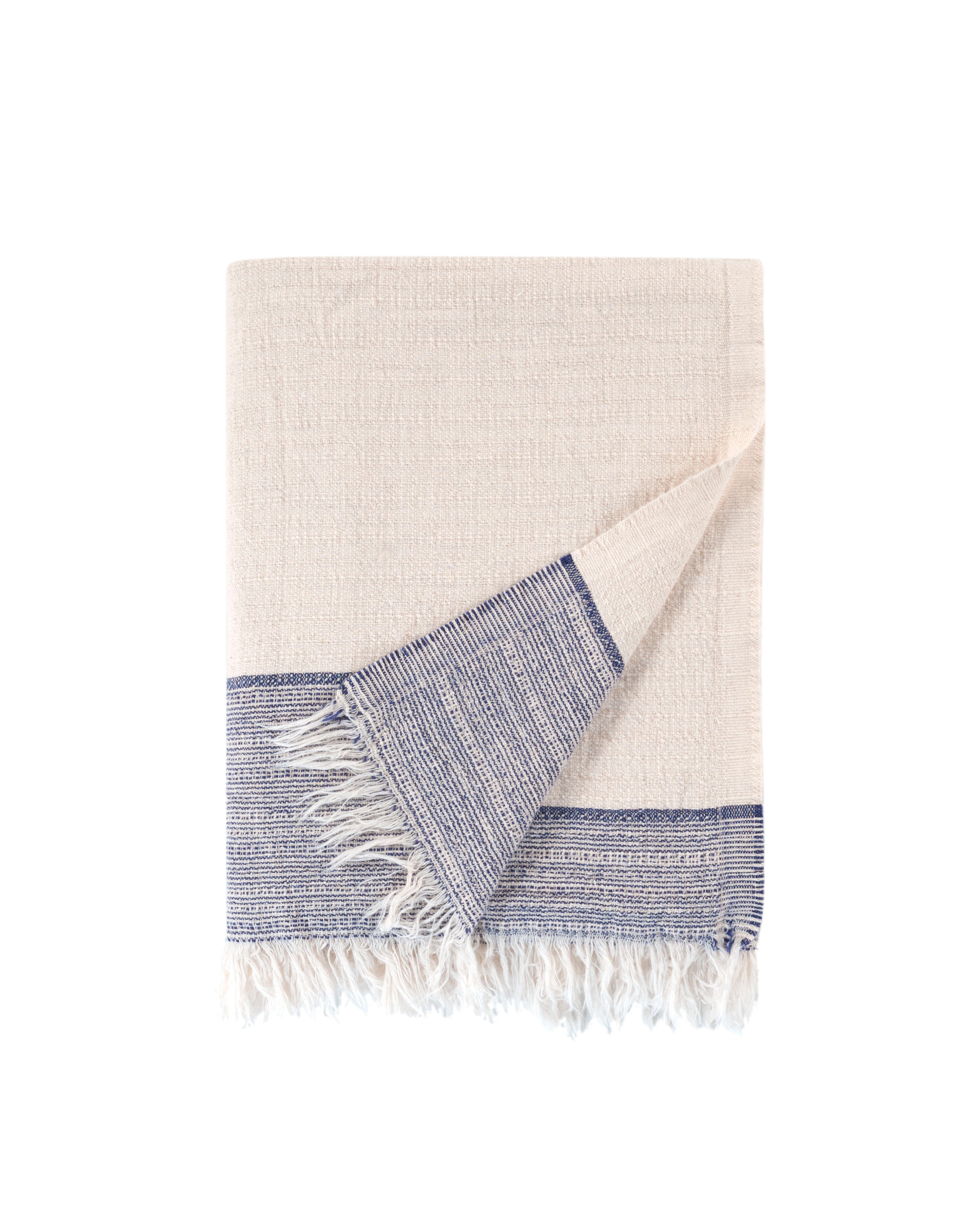Beige towel with blue border and white fringe on a white background