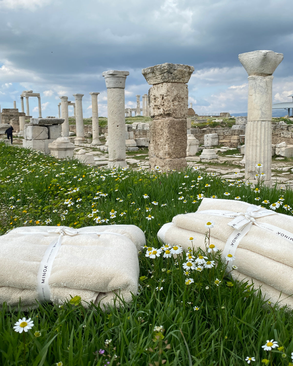 Monte Rosa towel sets bundled on a meadow in front of ruins.