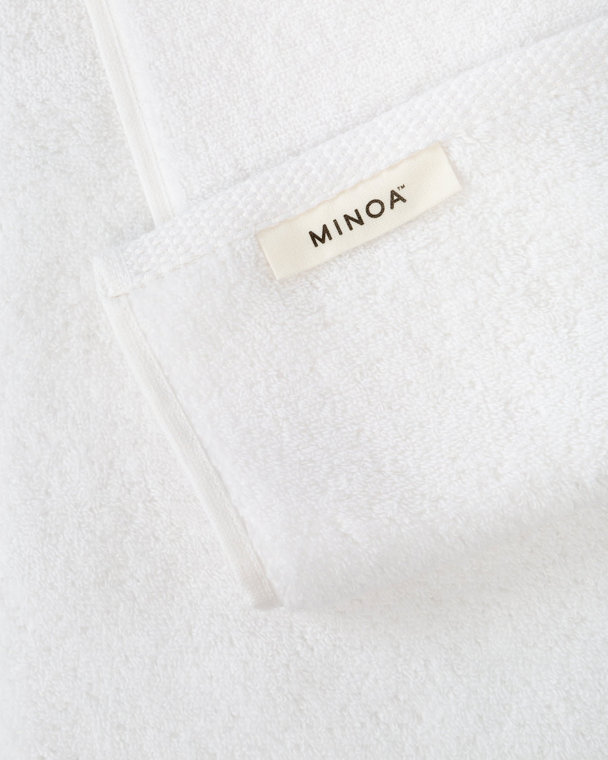 Close-up of a white towel with 'MINOA' label