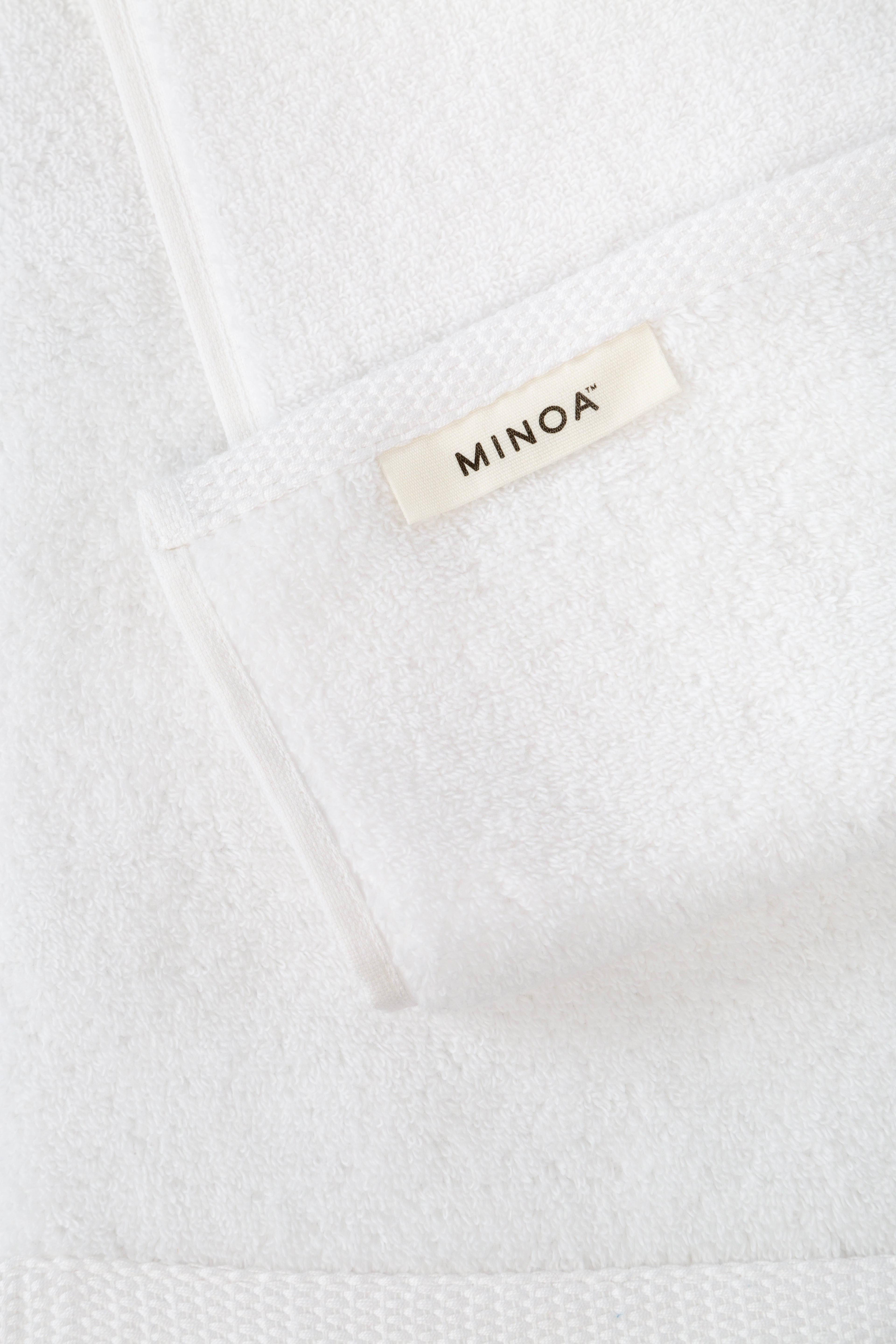 Close-up of a white towel with 'MINOA' label