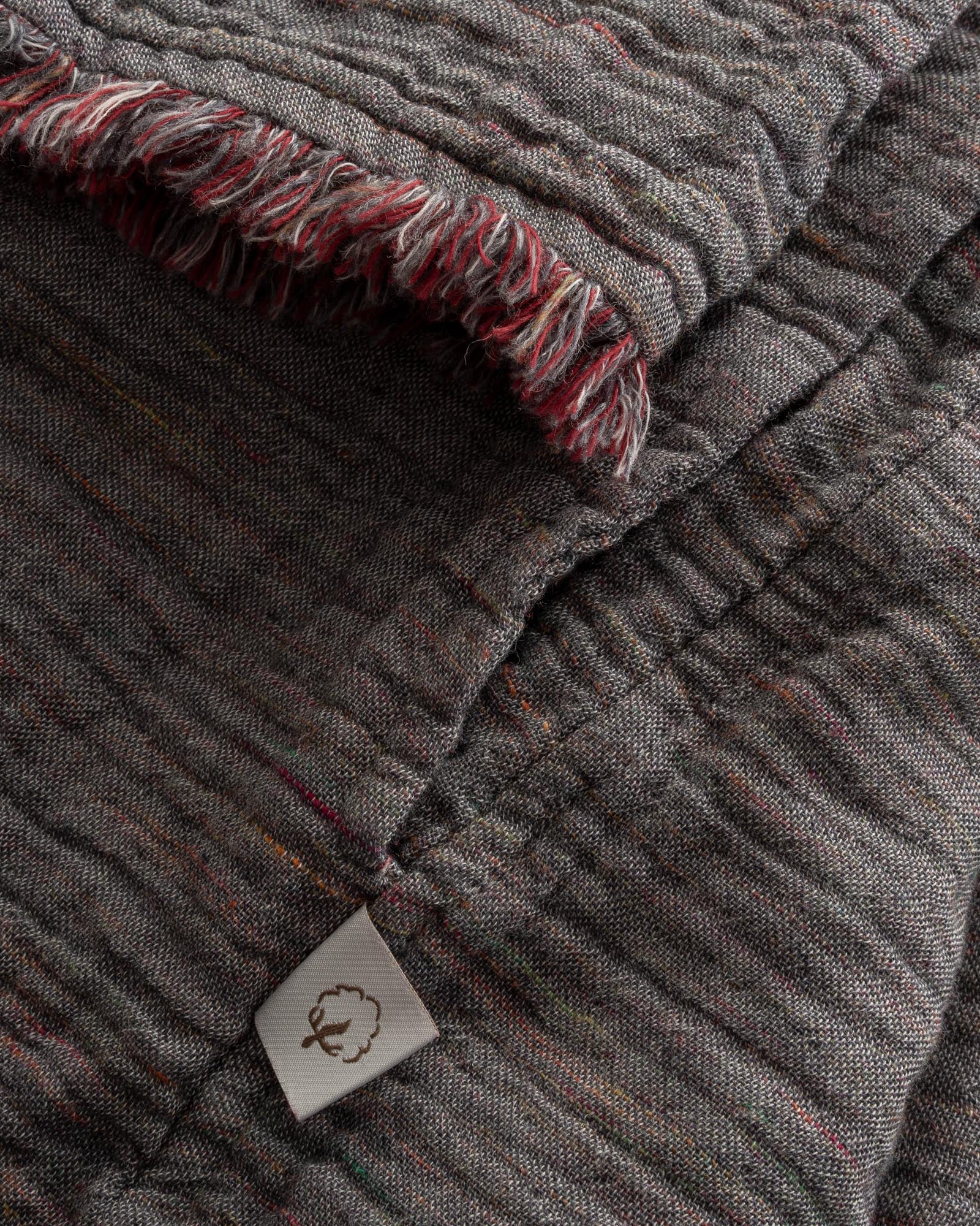 Close-up of the sleeve of the Women's Muna Organic Aegean Cotton Gauze Two-Sided Robe in Bordeaux Bliss, showcasing the fabric's detailed stitching and elegant design
