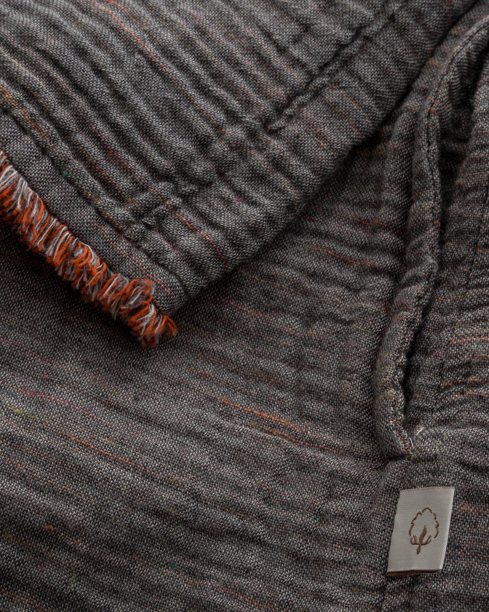 Close-up of the sleeve of the Women's Muna Organic Aegean Cotton Gauze Two-Sided Robe in Bordeaux Bliss, showcasing the fabric's detailed stitching and elegant design