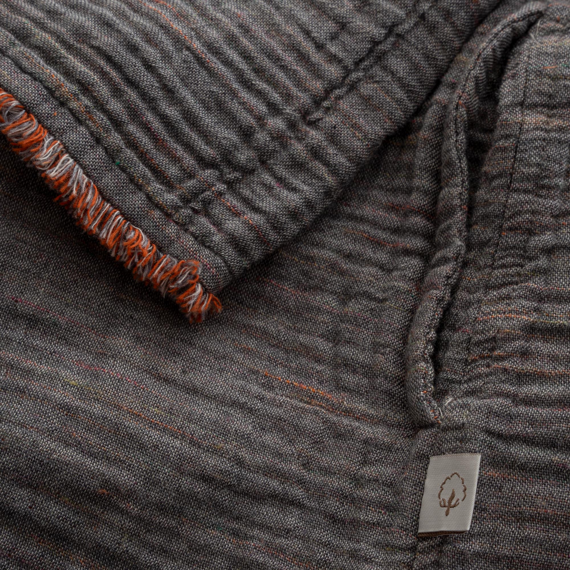 Close-up of the sleeve of the Women's Muna Organic Aegean Cotton Gauze Two-Sided Robe in Bordeaux Bliss, showcasing the fabric's detailed stitching and elegant design