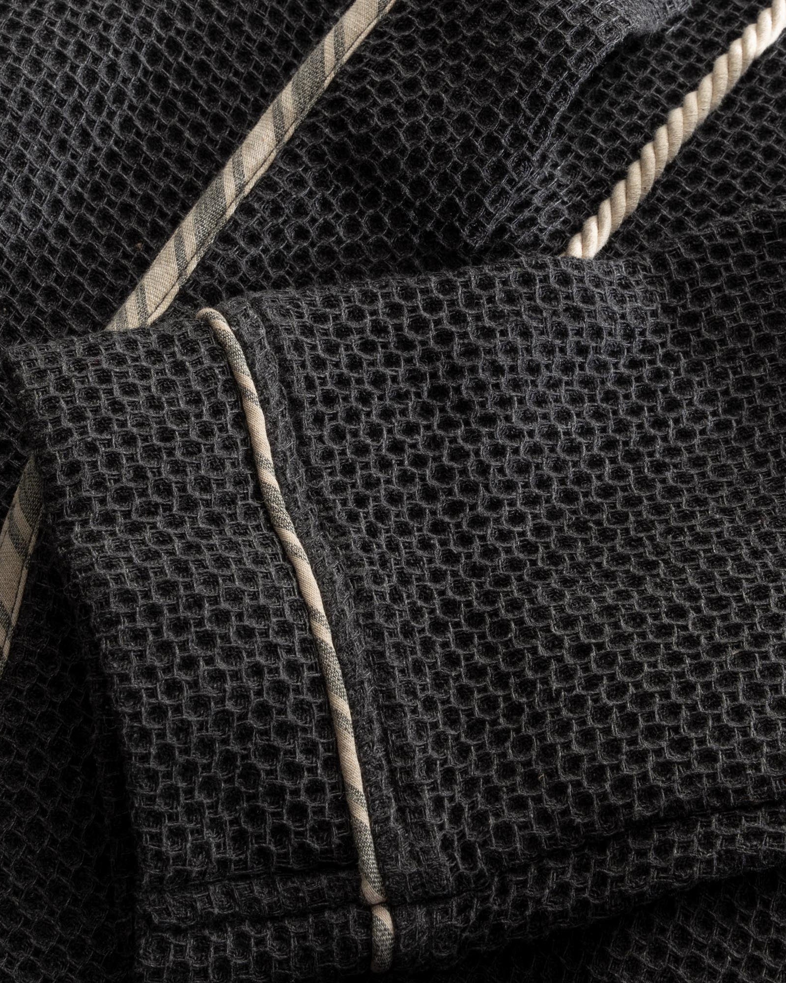 A close up shot of Minoa's Naia Panama Weave Mens Robe showing its robe sleeve with fine texture