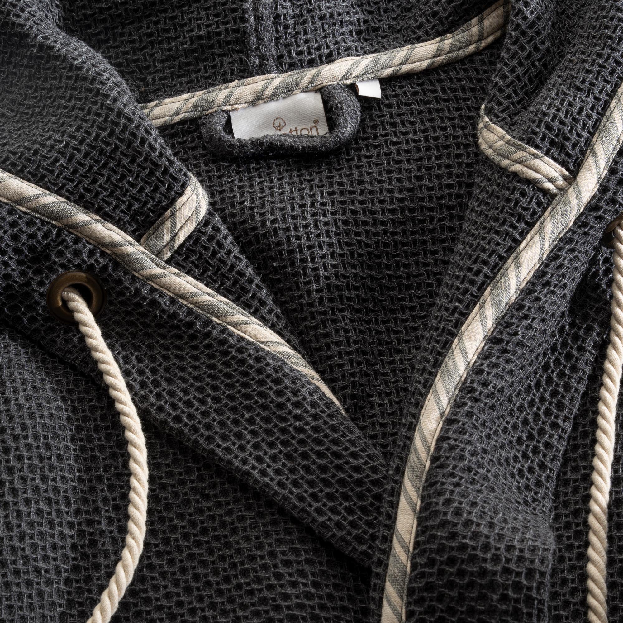 A close up shot of Minoa's Naia Panama Weave Mens Robe showing the EcoCotton Brand Tag