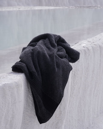 Black towel draped over a textured white surface
