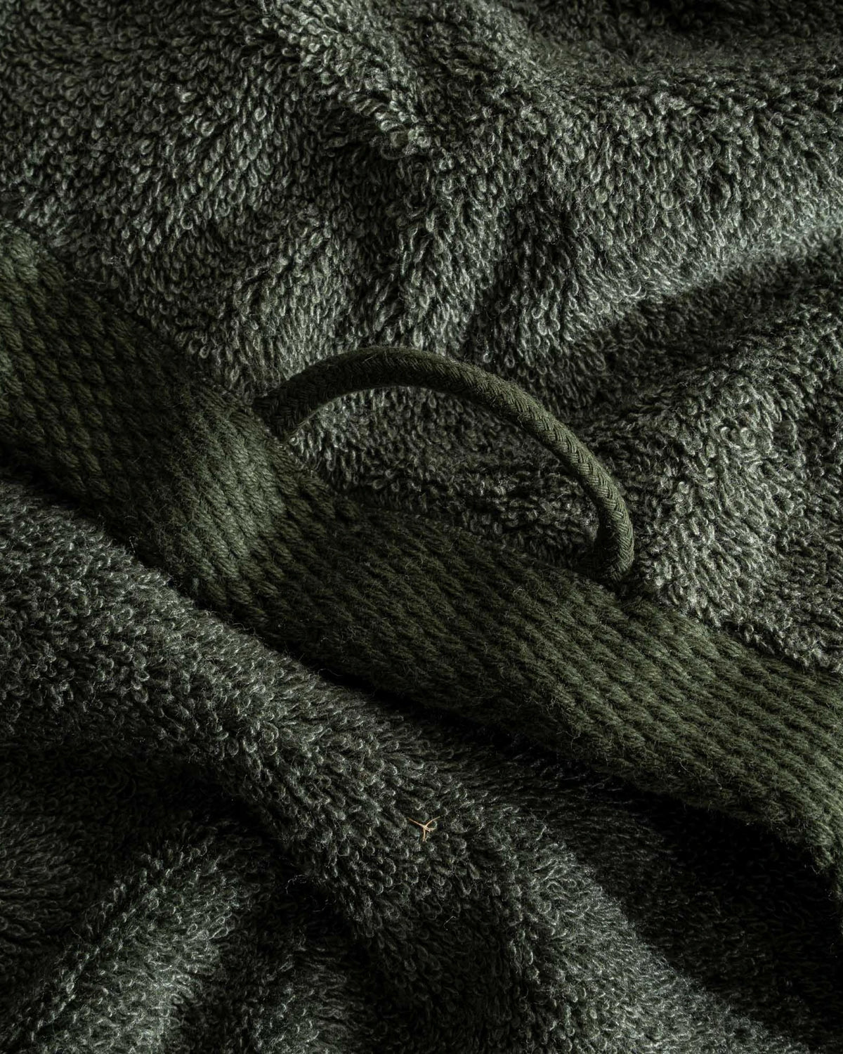 Close-up of dark green textured towel with a knitted pattern