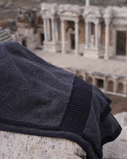 Dark gray towel on stone steps with ancient ruins in the background