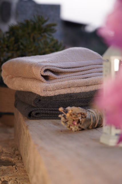 Honey Latte and Charcoal Embrace Plush Lite Aegean Cotton Bath Towels neatly folded, showcasing the soft texture and elegant colours of organic and luxury bath towels