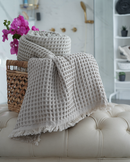 Minoa USA Canada Seren organic cotton waffle luxury bath towels rolled up in a basket showcasing sustainable luxury