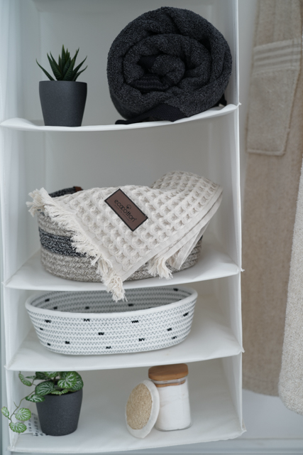 Minoa USA Canada Seren organic cotton waffle luxury bath towels stocked on a shelf with bath tools, highlighting their plush texture and sustainable luxury