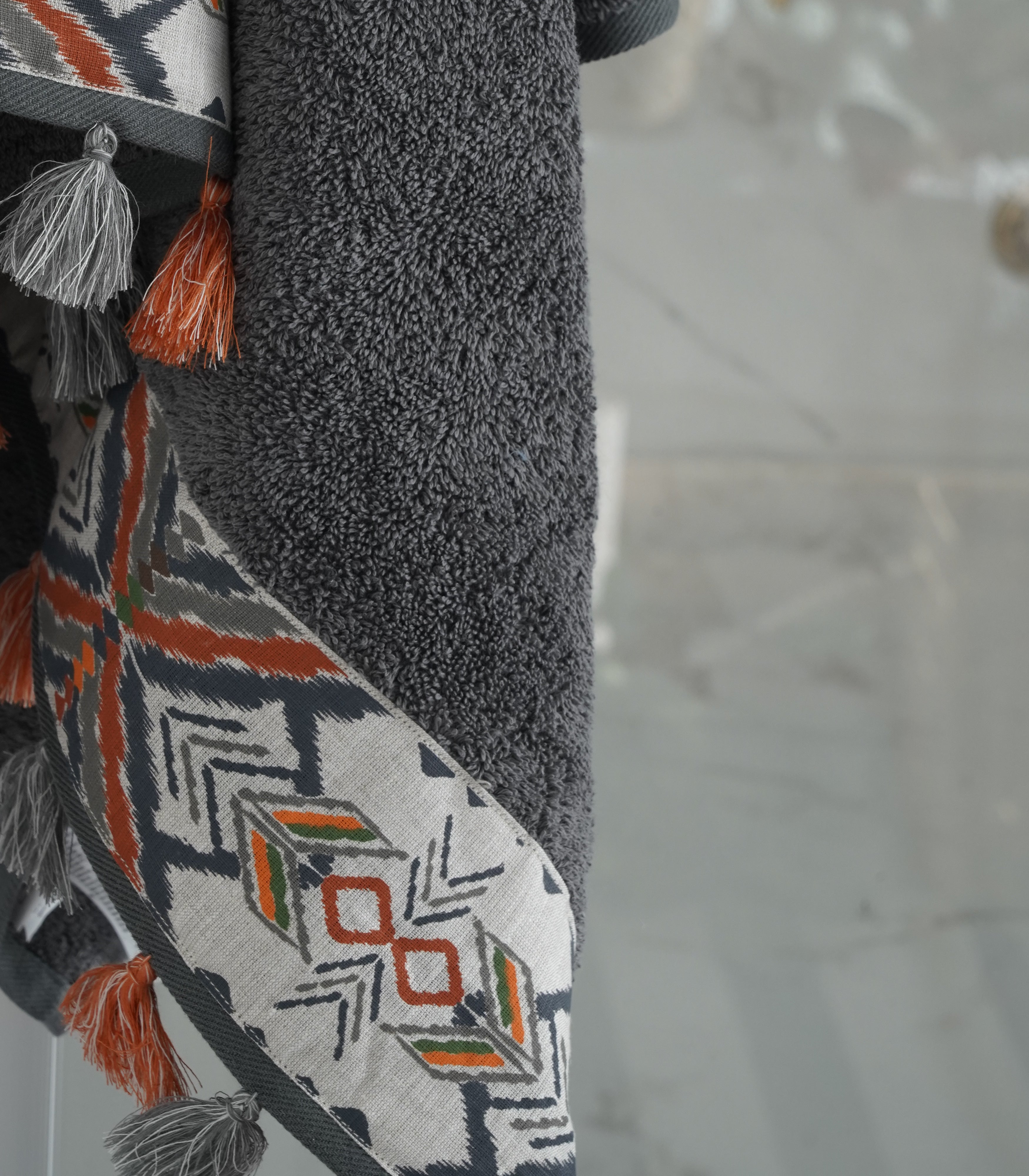 Close-up of the Pamira Organic Aegean Cotton Bath Towel in Dark Pearl, hanging, showing its soft texture, rich colour, and luxurious fabric