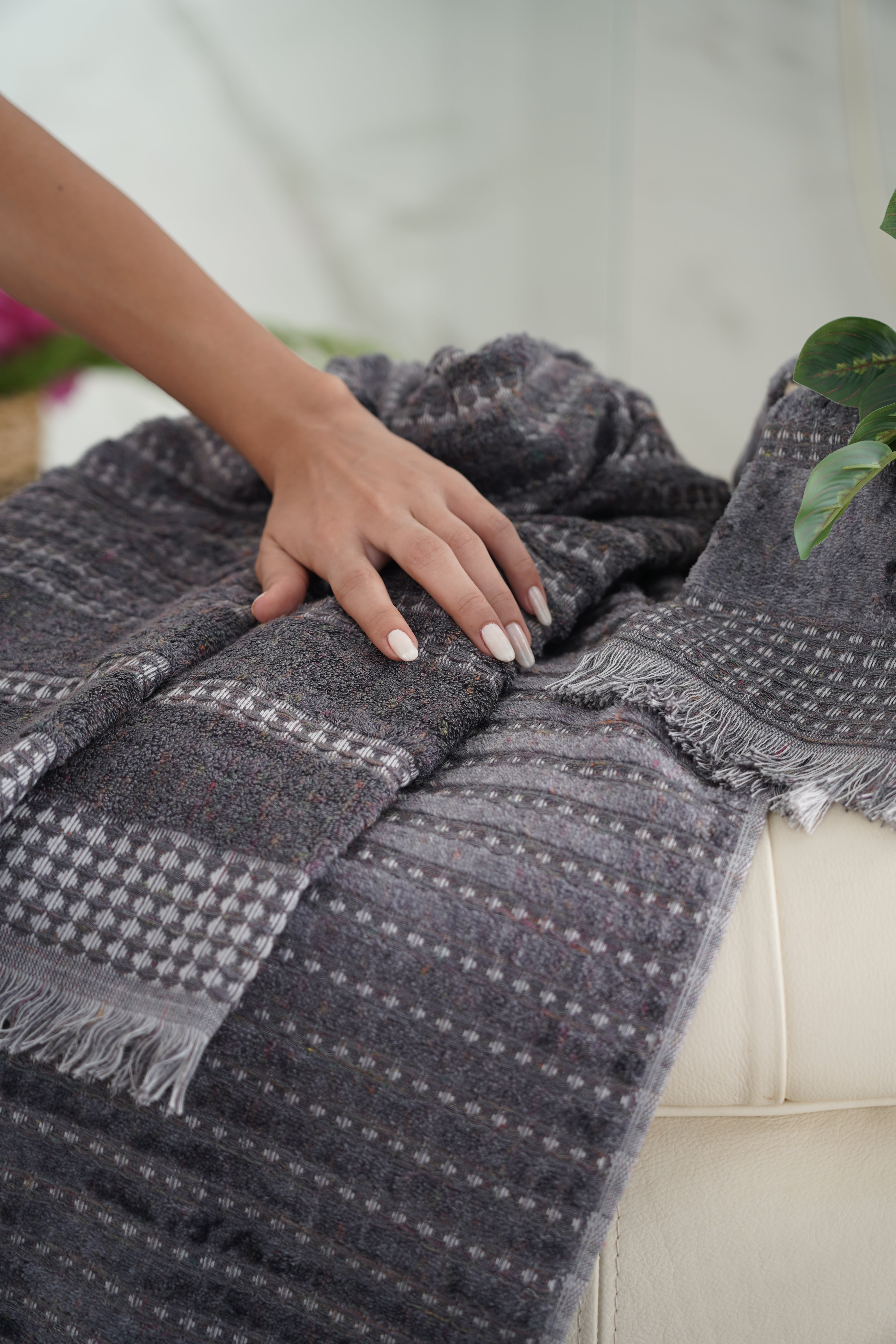 Zeus Organic Cotton Bath, Hand & Washcloth Set in Cozy Cobalt, with a woman’s hand gently holding or arranging the towels, highlighting the soft texture and vibrant colour