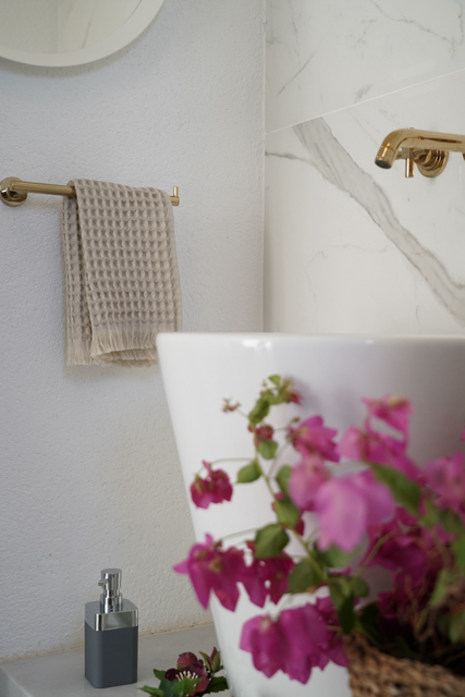 Minoa USA Canada Seren organic cotton waffle luxury bath towels displayed in a washroom with flowers, showing their plush texture, elegance, and sustainable luxury