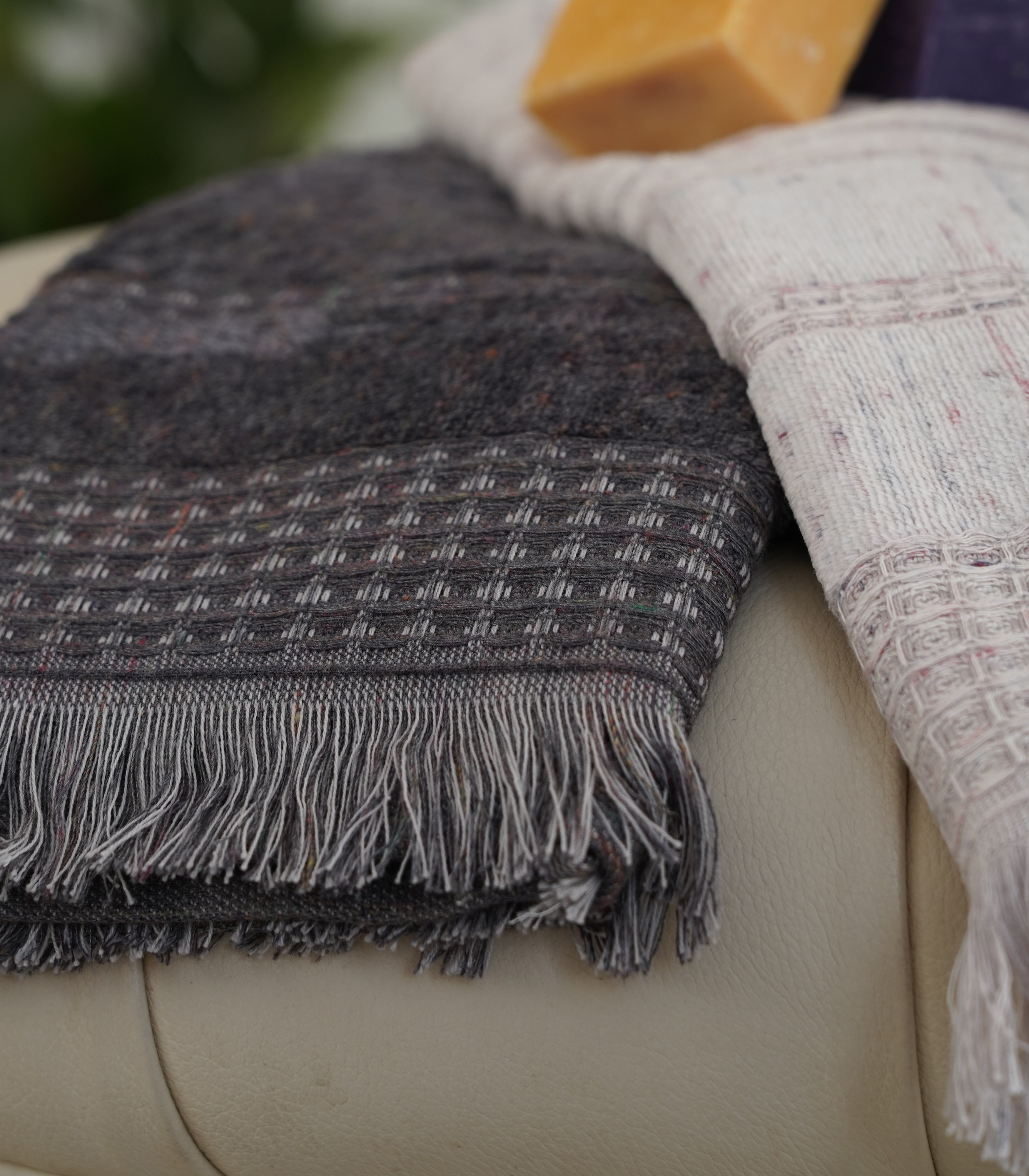 Close-up of the Zeus Organic Cotton Bath, Hand & Washcloth Set in Cozy Cobalt, with a woman’s hand gently holding or adjusting the towels, showcasing their soft texture and rich colour