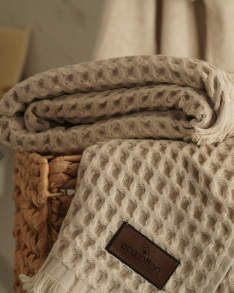 Close-up of Minoa USA Canada Seren organic cotton waffle luxury bath towels in a shower room, showing their plush texture, elegance, and sustainable luxury