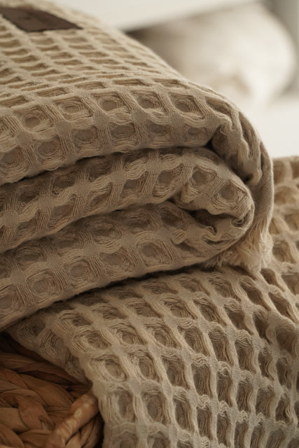 Close-up of beige Organic Aegean Seren Waffle Large Throw/Bed Spread 400-gram, showcasing its soft waffle texture and eco-friendly organic cotton construction