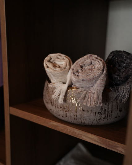 Maia organic bath towels set by Minoa USA Canada, sustainably made from organic cotton and viscose, rolled up neatly in a basket for a luxury bath presentation