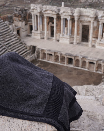 Minoa USA Canada sustainable luxury hand towel from the Naia and cotton collection, displayed with an ancient artifacts background, highlighting soft texture and premium quality fabric