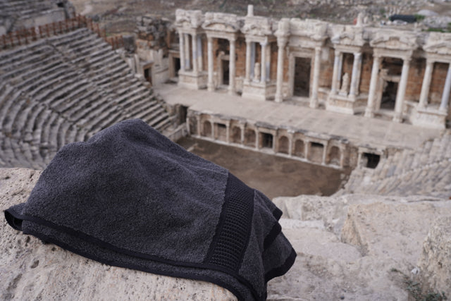 Minoa USA Canada sustainable luxury hand towel from the Naia and cotton collection, displayed with an ancient artifacts background, highlighting soft texture and premium quality fabric